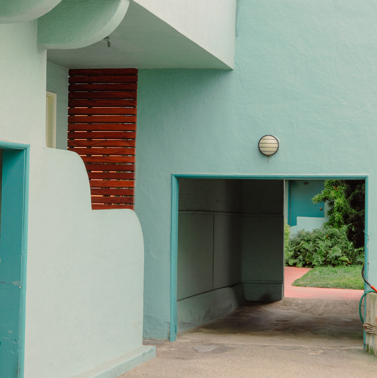 a driveway into a light green building